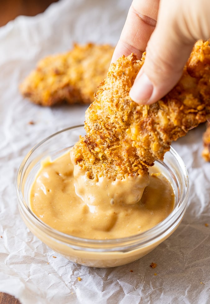 Dipping chicken tenders in Chick Fil A Sauce