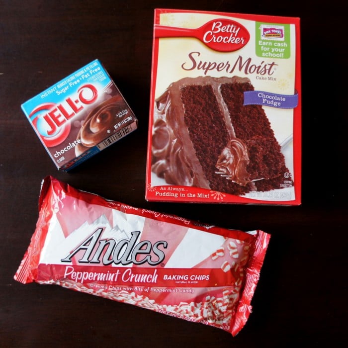 A display of ingredients needed to make Peppermint Poke Cake; a box of chocolate cake, chocolate pudding and Andes mints