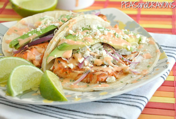 A close up of two fish tacos on a plate
