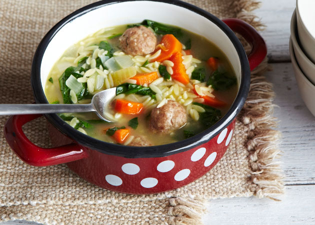 A pot of soup with meatballs and veggies