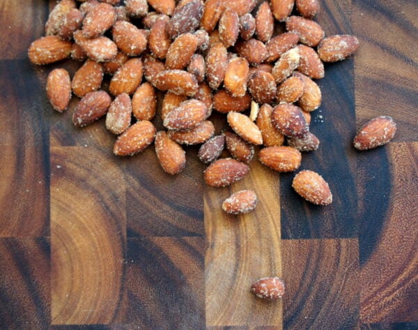 A wooden surface with a pile of almonds on it