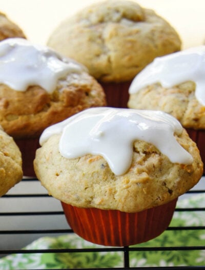 A close up of muffins on a cooling rack topped with white glaze