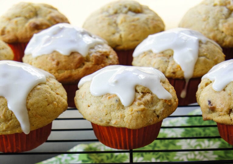A close up of muffins on a cooling rack topped with white glaze