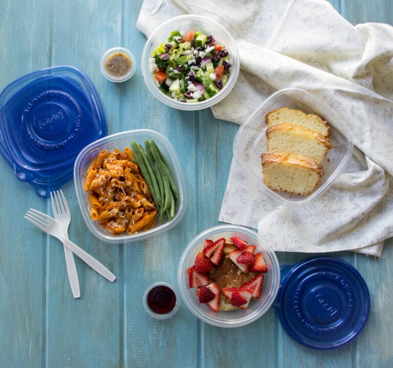 Plastic containers with healthy lunch options displayed on a wooden surface