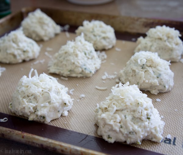 A pan with raw Quick Parmesan and Herb Biscuits rolled in cheese