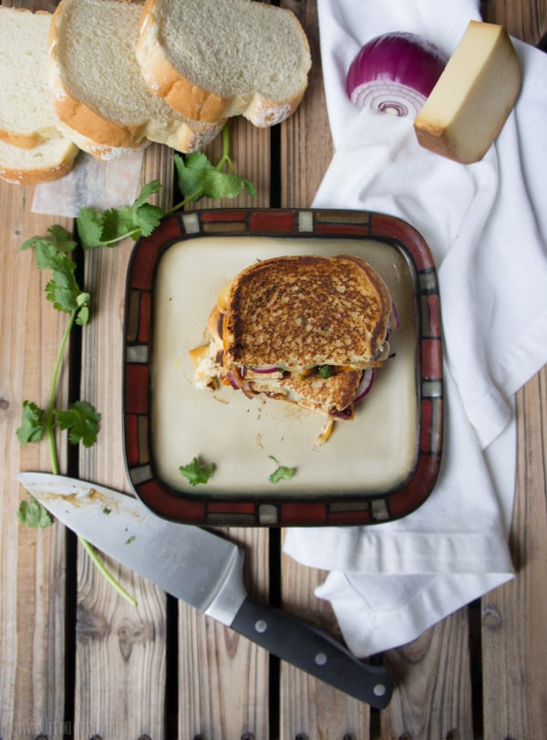 A toasted sandwich on a plate on a wooden surface 