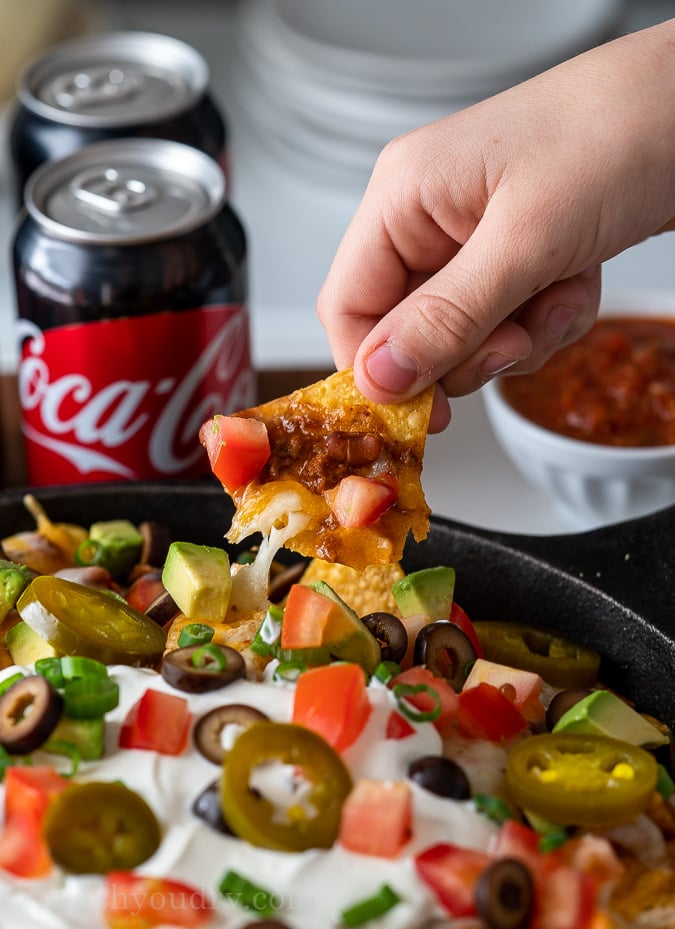 hand pulling chip out of nachos