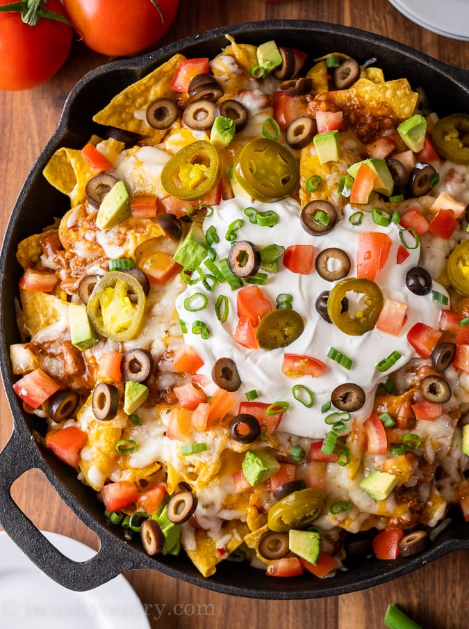 plate of crispy, cheesy nachos with toppings