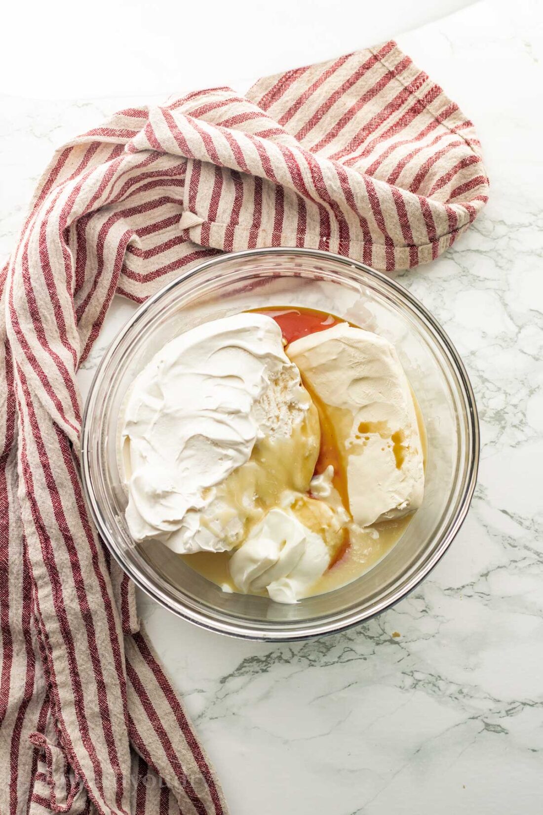 Cream cheese, coolwhip, vanilla, and condensed milk in glass bowl. 