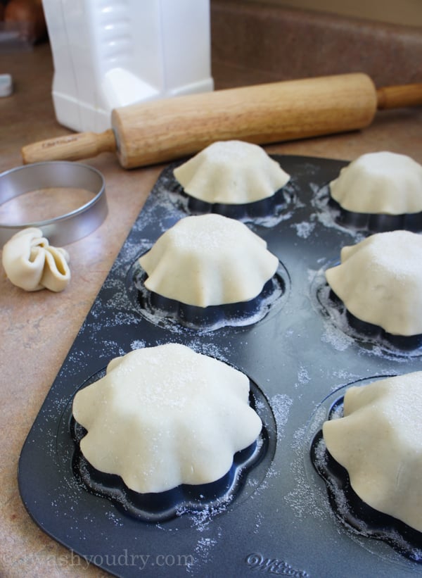 A close up of mini pie tin shaping raw dough to make crust for Mini Fresh Fruit Pies