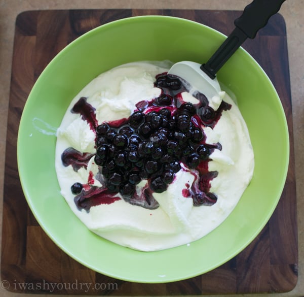 blueberry sauce in green bowl with vanilla ice cream.
