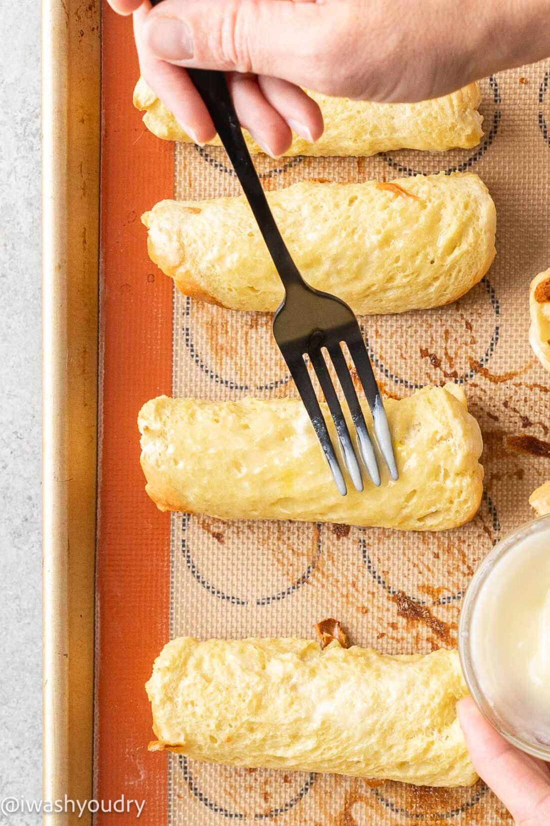 brushing french toast rolls with butter.