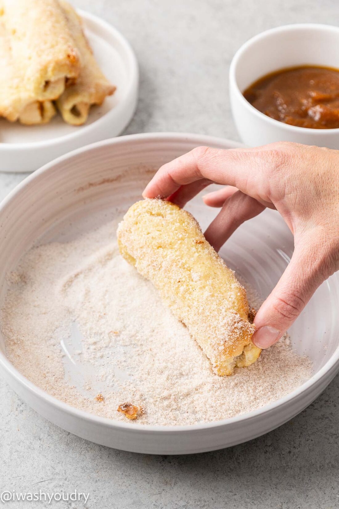 rolling french toast in sugar mixture.