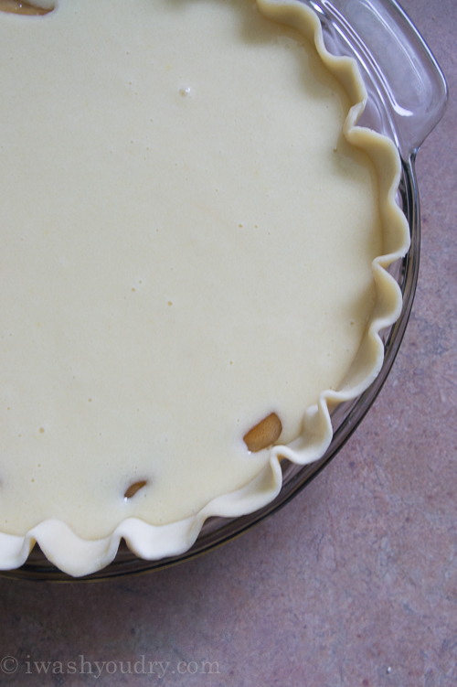 A close up of apple pie streusel base being topped with cake batter