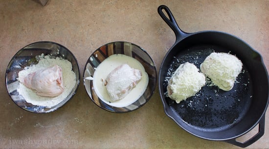 A display of bowls and a skillet to demonstrate the process on how to dip Caesar Chicken Thighs