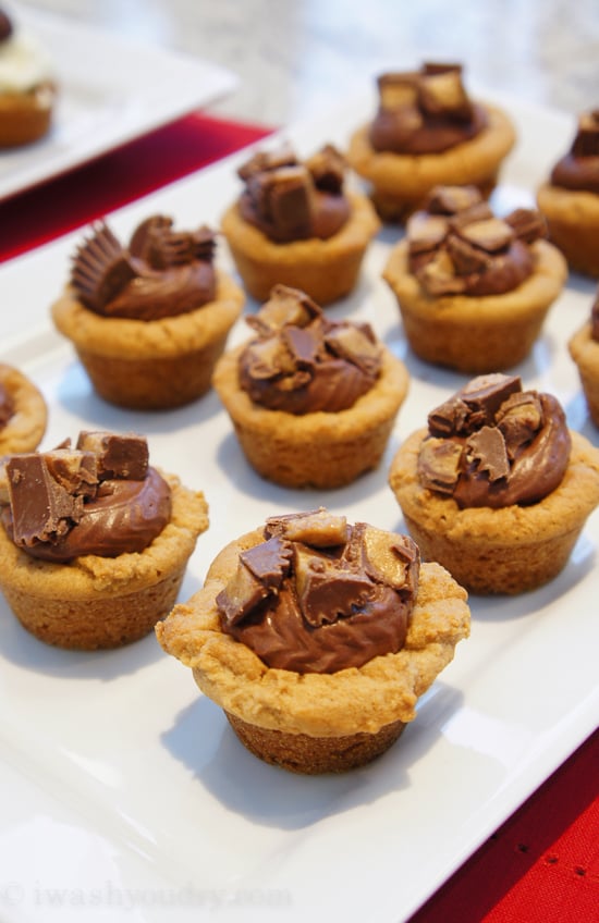 A plate of mini muffin sized cookies topped with chopped candy pieces