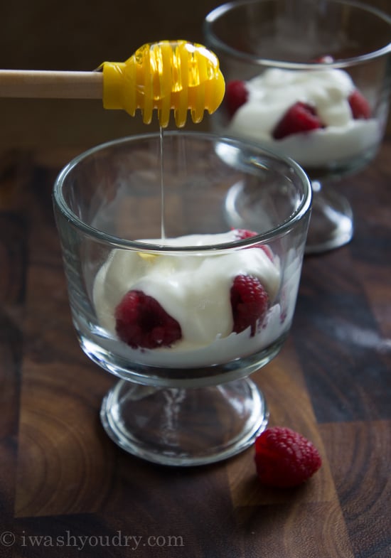 A dessert cup demonstrating how to layer the Raspberry Greek Yogurt Parfait