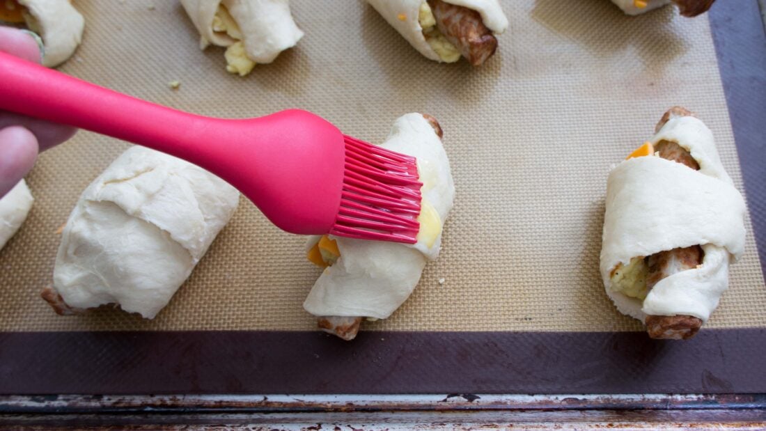 brushing the tops of roll ups with whisked eggs.