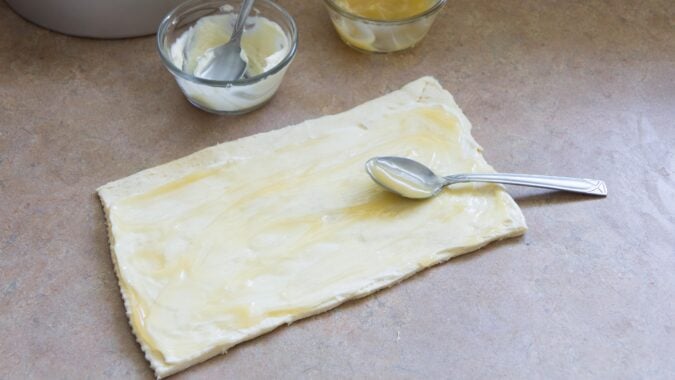 Spread the cream cheese and lemon curd mixture over the crescent roll dough.