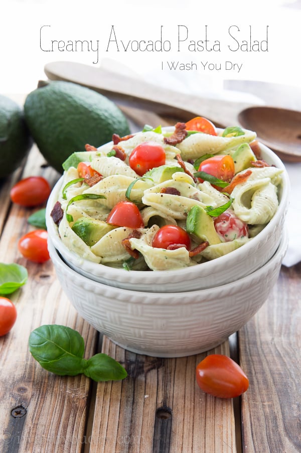 A bowl of salad, with pasta, avocado and tomatoes