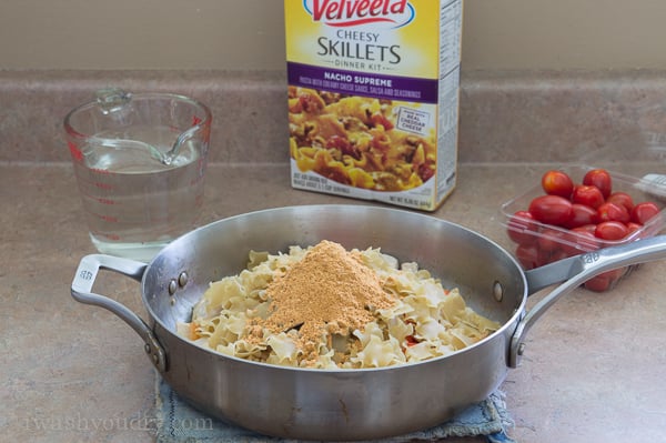 A skillet with all the ingredients to make One Skillet Cheesy Chicken Nacho Supreme before it is mixed together