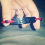 A close up of a bracelet that says "Rise Up Toliver"