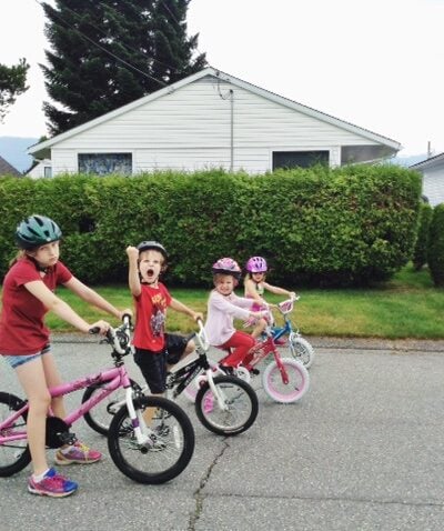Four kids in the road on bikes riding