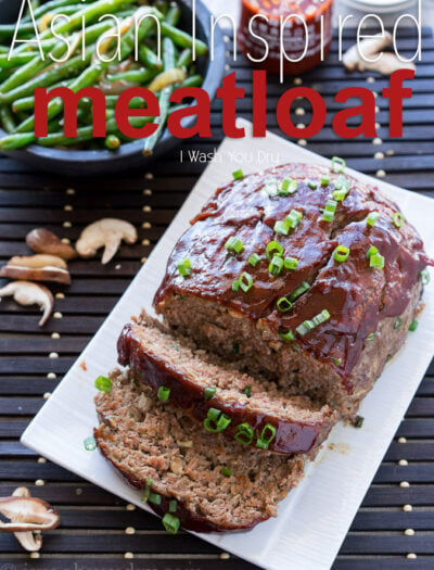A meatloaf on a white serving plate with 2 slices made in it.
