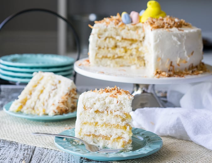 two slices of coconut cake with a fork and two blue plates.