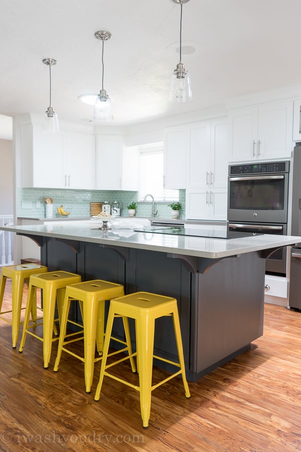 Love the pop of color from the bar stools and back splash. Grey island paint color is "Peppercorn" by Sherwin Williams.