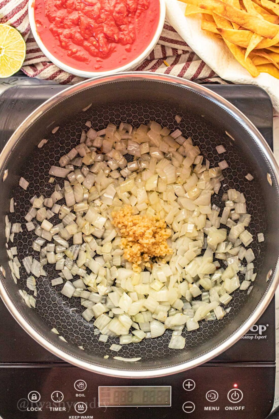 Chopped onions and garlic in black pan. 