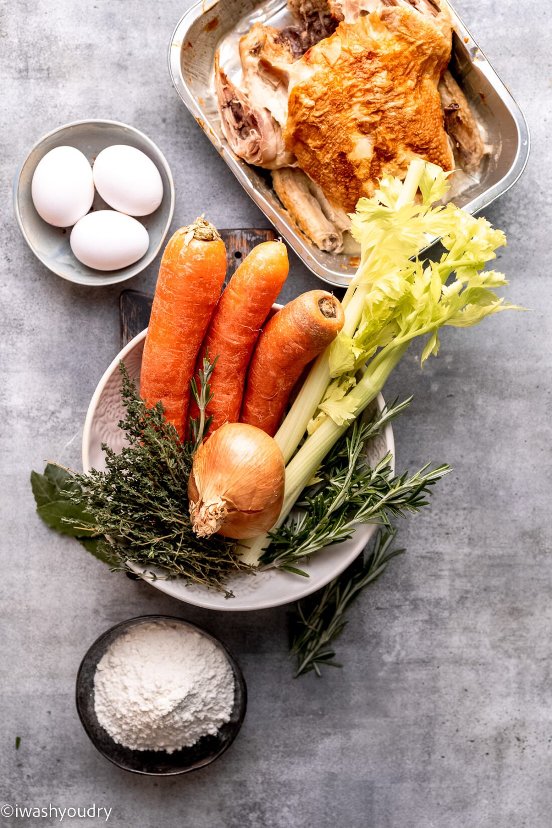 Ingredients for homemade turkey noodle soup on gray countertop. 