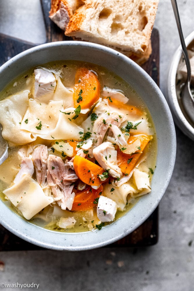 Cooked turkey noodle soup in white bowl.