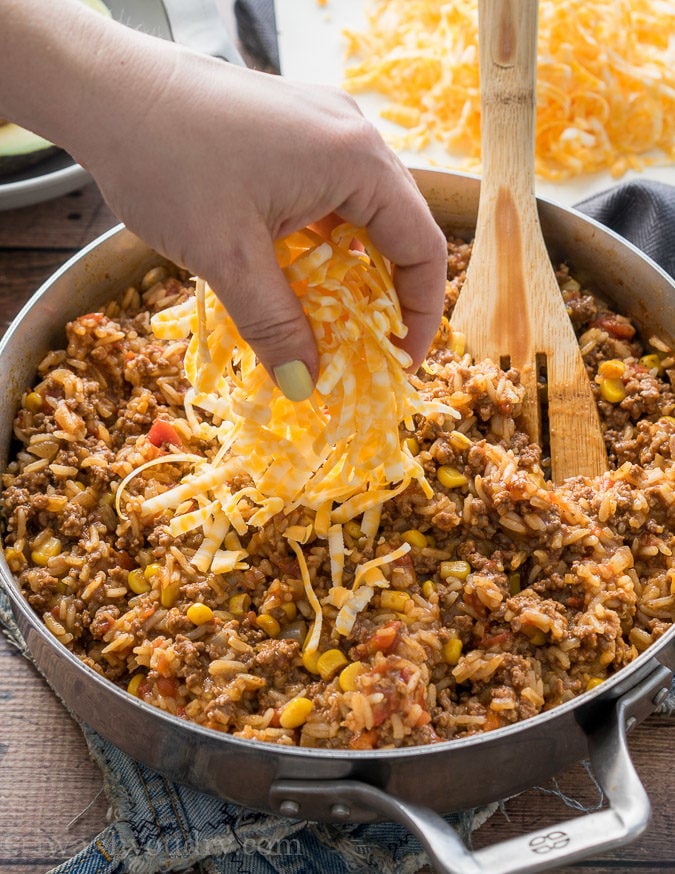 Fork lifting up bite of rice with ground beef and cheese