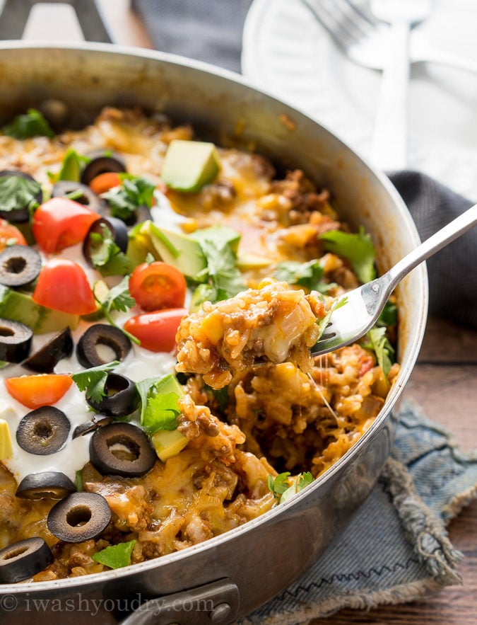 fork lifting up bite of rice with ground beef and cheese