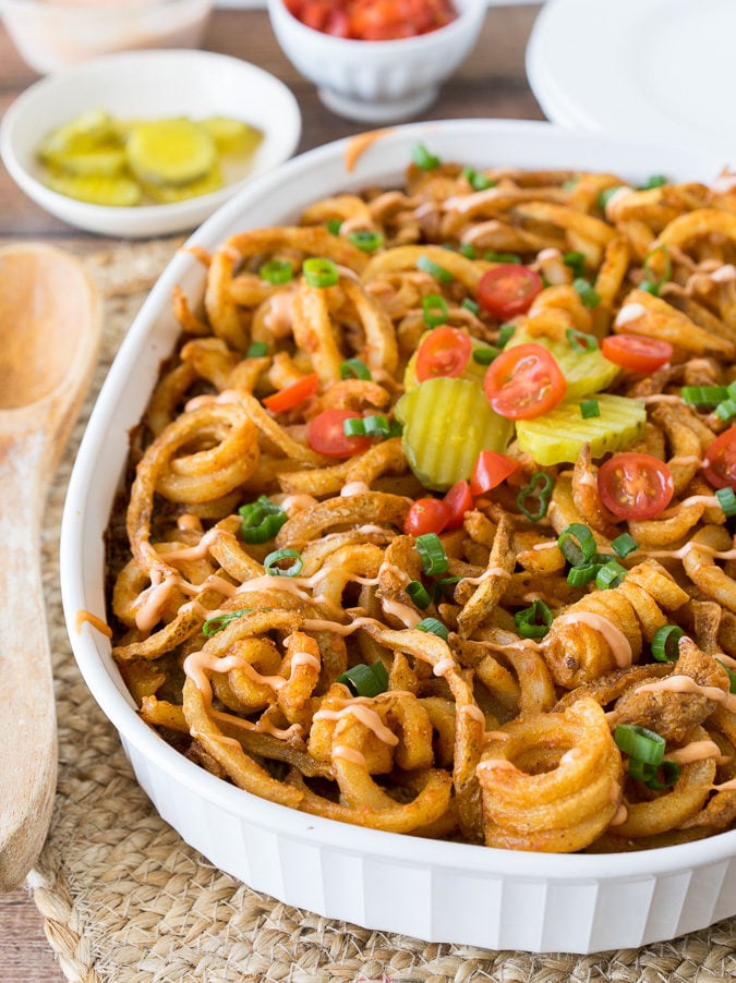 This Cheeseburger and French Fry Casserole is filled with all the hamburger favorites and even topped with crispy seasoned french fries and a creamy fry sauce!