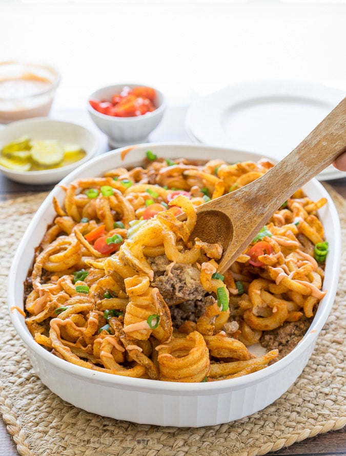 This Cheeseburger and French Fry Casserole is filled with all the hamburger favorites and even topped with crispy seasoned french fries and a creamy fry sauce!