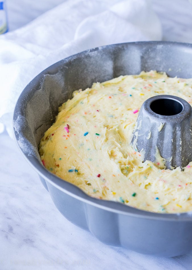 This Cherry Surprise Cake is a moist funfetti cake that's filled with cherry pie filling! So fun and so delicious, my whole family loved it!