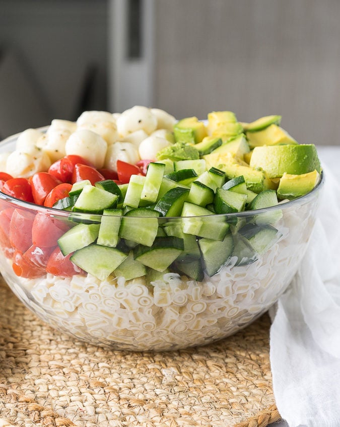 This Avocado Caprese Pasta Salad is a cold pasta salad that is perfect for parties and bbq's! Full of fresh veggies and creamy pasta!