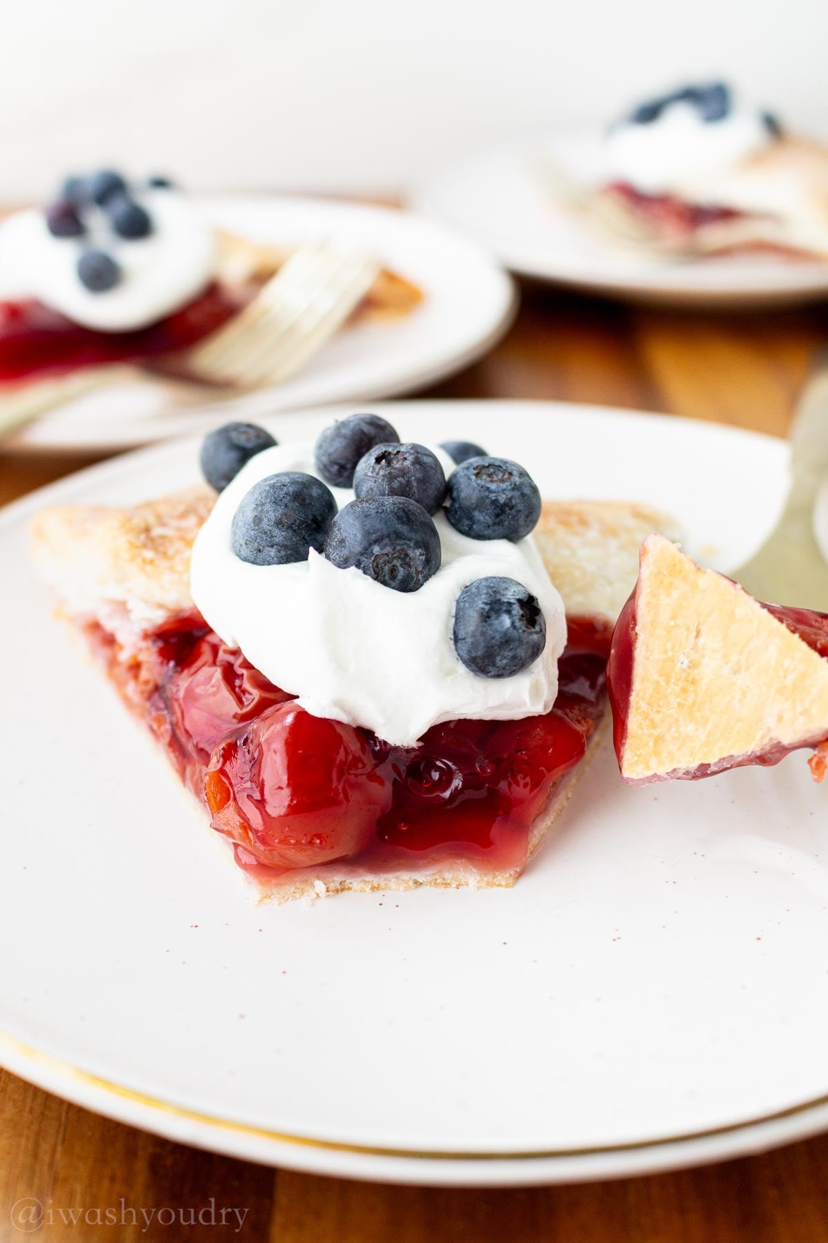 bite taken out of cherry galette with fork and cherries.