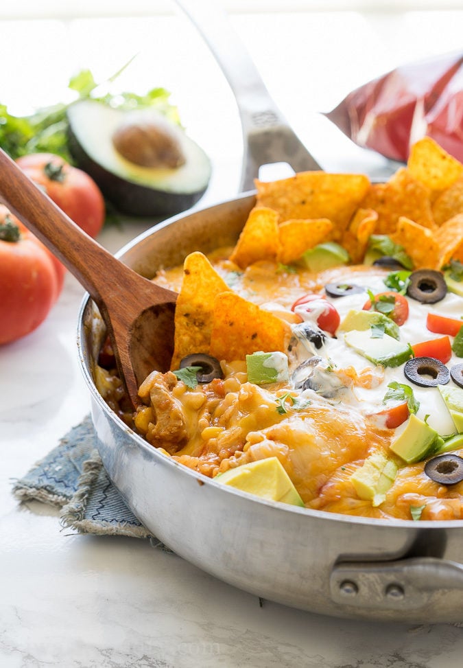 This one pan, Mexican Chicken Taco Skillet is filled with chicken, rice and corn, then topped with all the yummy taco fixin's for a delicious dinner recipe that my family requests over and over again!