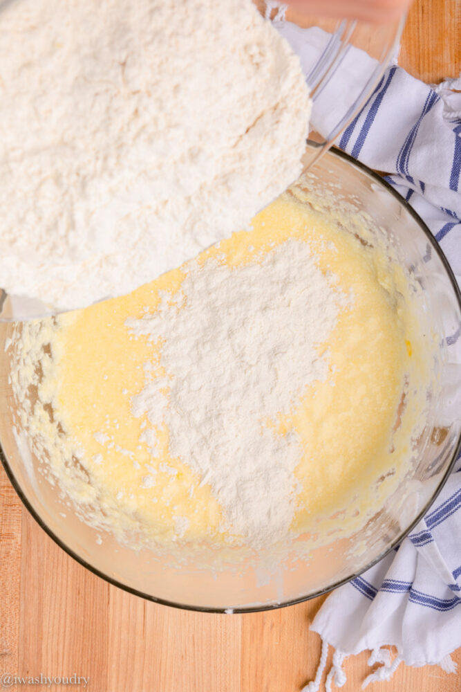 pouring dry flour ingredients into bowl with batter.