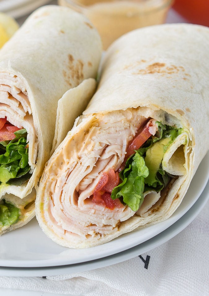 These Cajun Turkey Avocado Wraps are the perfect way to spruce up your lunch box! Filled with thinly sliced deli turkey, plump tomatoes, creamy avocado and a zippy cajun mayo, these wraps are bursting with flavor!