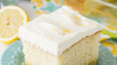 A square of lemon cake on a plate with white frosting