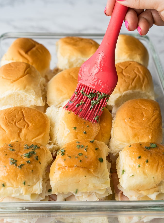 estes Fliders de frango amanteigado com Cordon Bleu têm camadas de queijo suíço, fiambre fino em fatias e frango com um molho de mostarda de mel irresistível no pão macio amanteigado, em seguida cozido até quente e extra pegajoso. 