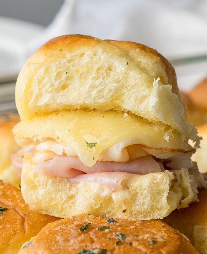 These Buttery Chicken Cordon Bleu Sliders have layers of swiss cheese, thinly sliced deli ham and chicken with an irresistible honey mustard sauce on buttery soft roll, then baked till hot and extra gooey.