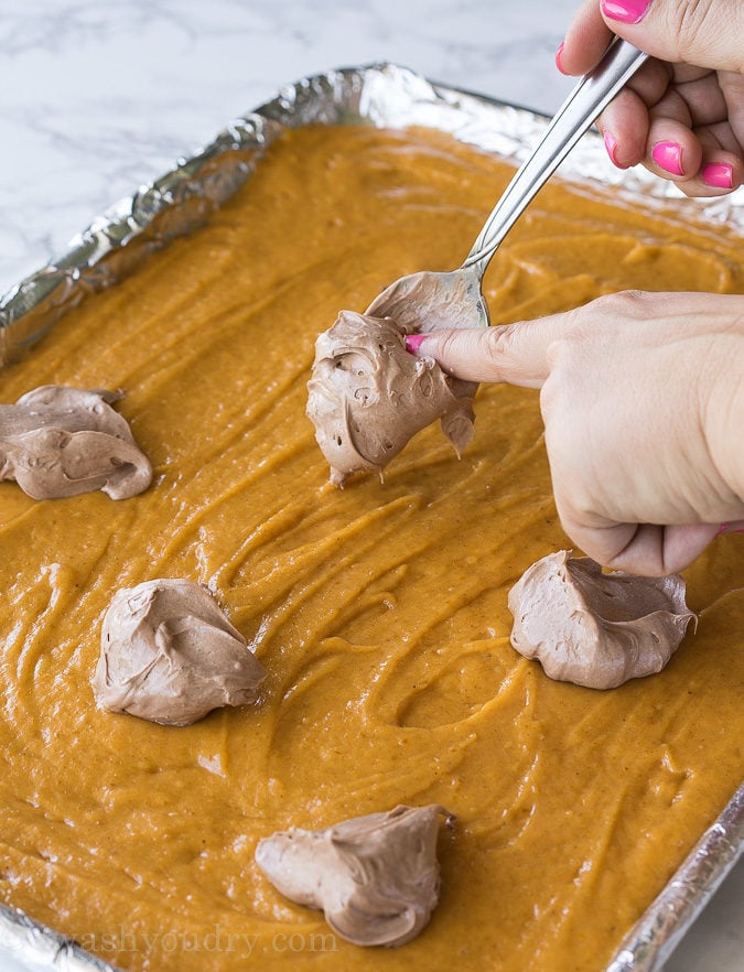 These Chocolate Swirled Pumpkin Bars are made on a large baking sheet, which make them perfect for taking to pot lucks and parties this Fall! I love that chocolate cheesecake swirled throughout too!