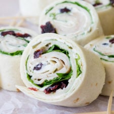 These Turkey Cranberry Pinwheels are filled with a creamy cream cheese, spinach, turkey and cranberries! Perfect for lunch or appetizers!