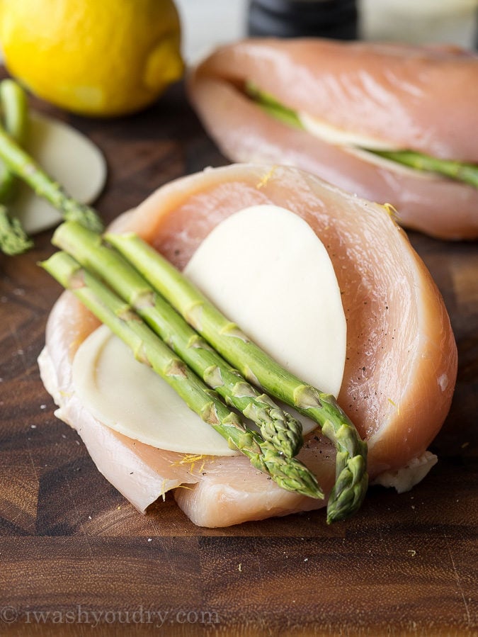 Asparagus and cheese inside uncooked chicken breast