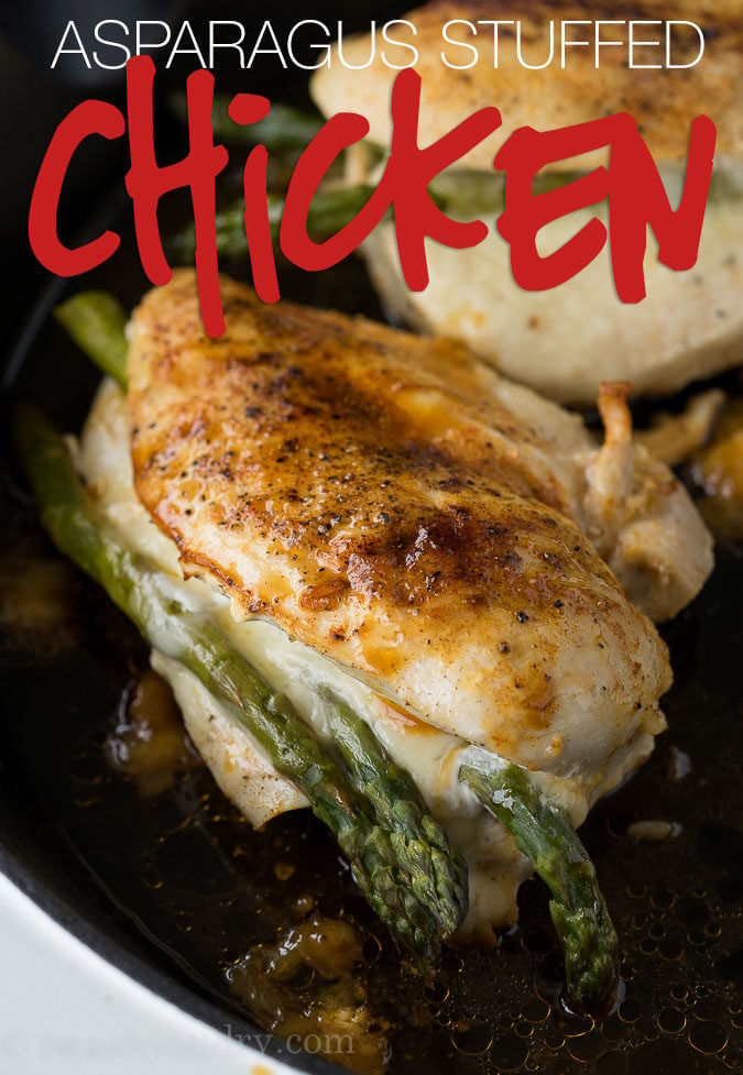 chicken stuffed with asparagus and cheese in a black skillet.